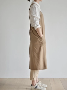 Side view of a khaki linen cotton apron featuring a practical pocket for gardening use