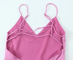 Détail d'une robe midi en satin rose avec dos nu et bretelles croisées délicates à lacets