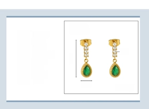 Macro detail of 18K gold plated teardrop earring with white pearls and green gemstone