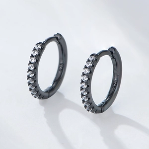 Macro detail of black s925 silver hoop earrings featuring micro-set sparkling cubic zirconia