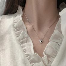 Dettaglio della collana con pendente a cuore in argento minimalista su modella