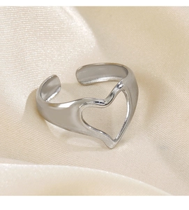 Detailed close-up of a silver heart-shaped adjustable ring on elegant white silk fabric