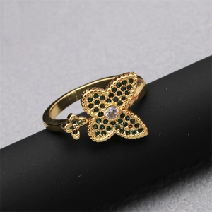 Bague ajustable dorée avec motif trèfle en zircon vert et pierre centrale étincelante