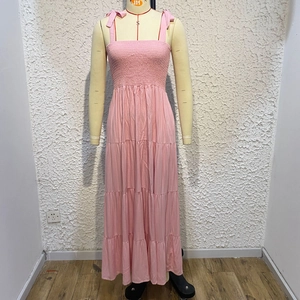 Detail of pink tiered sundress featuring adjustable bow straps and shirring chest design