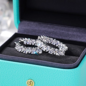 Close-up of luxury hoop earrings with marquise-cut cubic zirconia in a premium gift box