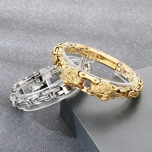 Detailed close-up of lion head biker bracelets in gold and silver steel on stands
