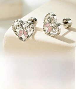 Detailed view of silver heart earrings with pink butterflies and beaded metal edges
