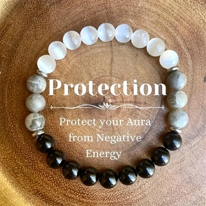 Detail of 8mm natural stone beaded bracelet with protection text in a wooden tray