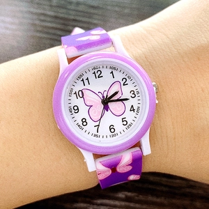 Close-up of a purple silicone kids watch with pink butterfly prints on a child's wrist
