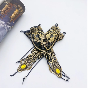 Macro shot of gothic black lace arm cuffs with gold embroidery and yellow gemstone