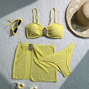 Detail of yellow three-piece bikini with textured fabric and teardrop metal accents