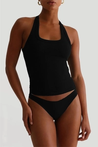 Detail eines schwarzen gerippten Y2K Halter Crop Tops und passender Slips am Model