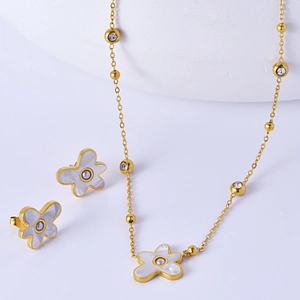 Minimalist gold necklace and earrings set with flower-shaped white shell and pearl accents