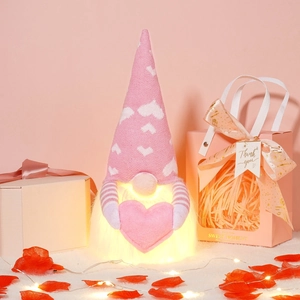 Detail of pink glowing Valentine's gnome doll with knitted heart hat and gift box