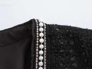 Detailaufnahme des Tweed-Kleides mit elegantem Perlen- und Strassbesatz am Halsausschnitt