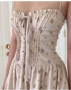 Detail of floral spaghetti strap dress with lace trim, smocked waist, and tie-up neckline