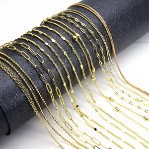 Macro view of various golden metal necklace chains including bead and paperclip styles