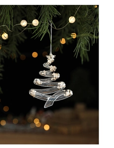 Detail of transparent acrylic Christmas tree ornament with gold sequins on pine branches