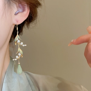 Detail of lily of the valley earrings with white buds and green resin water drops