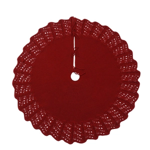 Detailed texture of red knitted Christmas tree skirt with hollow wavy patterns