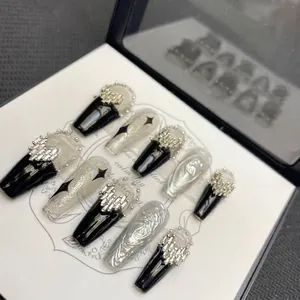 Faux ongles punk gothiques avec vernis noir, motifs argentés et dessins d'étoiles