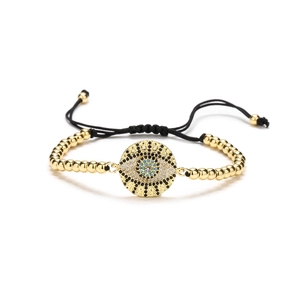 Adjustable golden bead bracelet featuring a cubic zirconia evil eye pendant with black cord