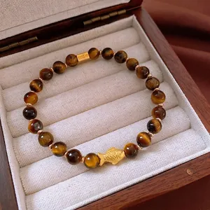 Bracelet en perles d'oeil de tigre avec charm poisson doré et détails en métal de qualité