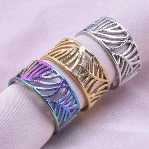 Trois bagues à motif feuille évidée en arc-en-ciel or et argent sur tissu rose