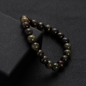 Detailed macro view of natural green chalcedony stone beads on a dark display box
