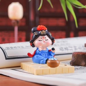 Detail of a Q-style ancient Chinese lady doll in blue Hanfu playing chess on a desk