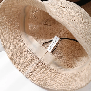 Detailed close-up of beige knitted sun hat showing interior sweatband and weave texture
