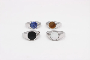 Detail view of round signet rings with blue, brown tiger eye, black, and white stones