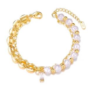 Close-up of double-layered gold bracelet with pearls and a crystal heart pendant