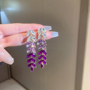Detail view of wheat leaf tassel earrings with sparkling rhinestones and gradient purple stones