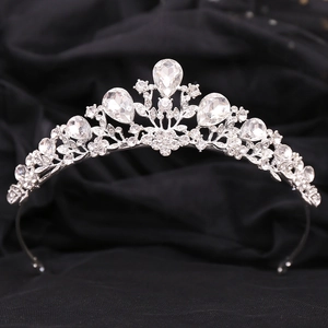 Close-up of a silver bridal tiara with rhinestones on a black silk background