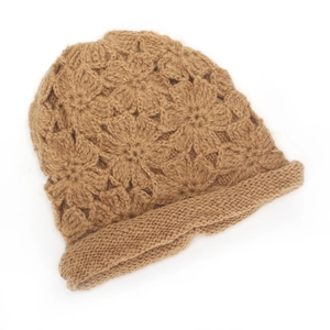 Close-up of handmade crochet knit beanie with hollow flower patterns and rolled edge