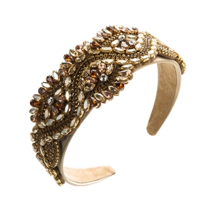 Detail shot of baroque headband with rhinestones and pearls on champagne satin fabric