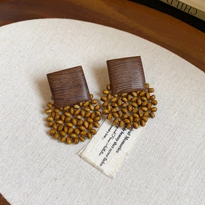 Detailed shot of retro tiger eye stone earrings with bohemian wooden beads on fabric