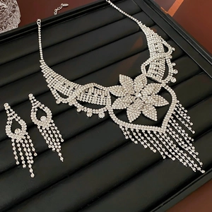 Detailed view of silver flower tassel necklace and teardrop earrings with rhinestones