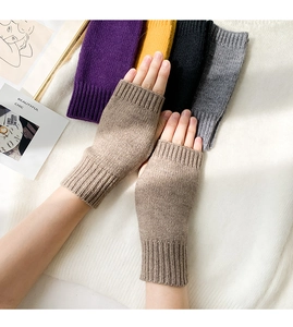 Macro shot of knitted fingerless gloves in light brown showing soft yarn texture