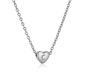 Macro detail of silver heart pendant with engraved letter C on a cross chain necklace