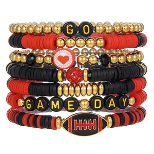 Detail view of seven stacked handmade football bracelets with GO and GAME DAY beads