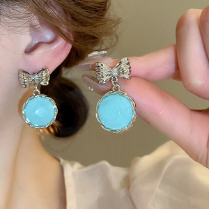 Vintage silver bow earrings with light blue resin beads in a classic round pleated style