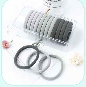 Set of 12 gradient grey velvet hair ties neatly stored in a clear plastic organizer box