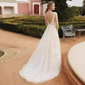 Elegant white lace wedding dress with V-back design and long train in garden setting