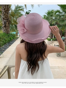 Pink wide-brim sun hat with large floral detail and woven texture for summer beach