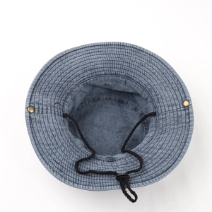 Detail of blue denim bucket hat with reinforced stitching and adjustable windproof cord