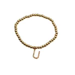 Detail of gold beaded elastic bracelet featuring a letter U charm with colorful stones