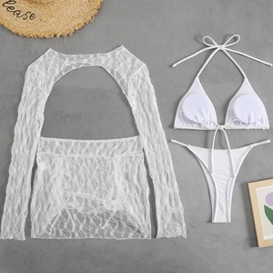 Dettaglio dell'ensemble bikini bianco in pizzo con copri-costume a maniche lunghe