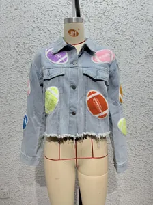 Detail of light blue denim jacket with colorful rugby patches and frayed hem design